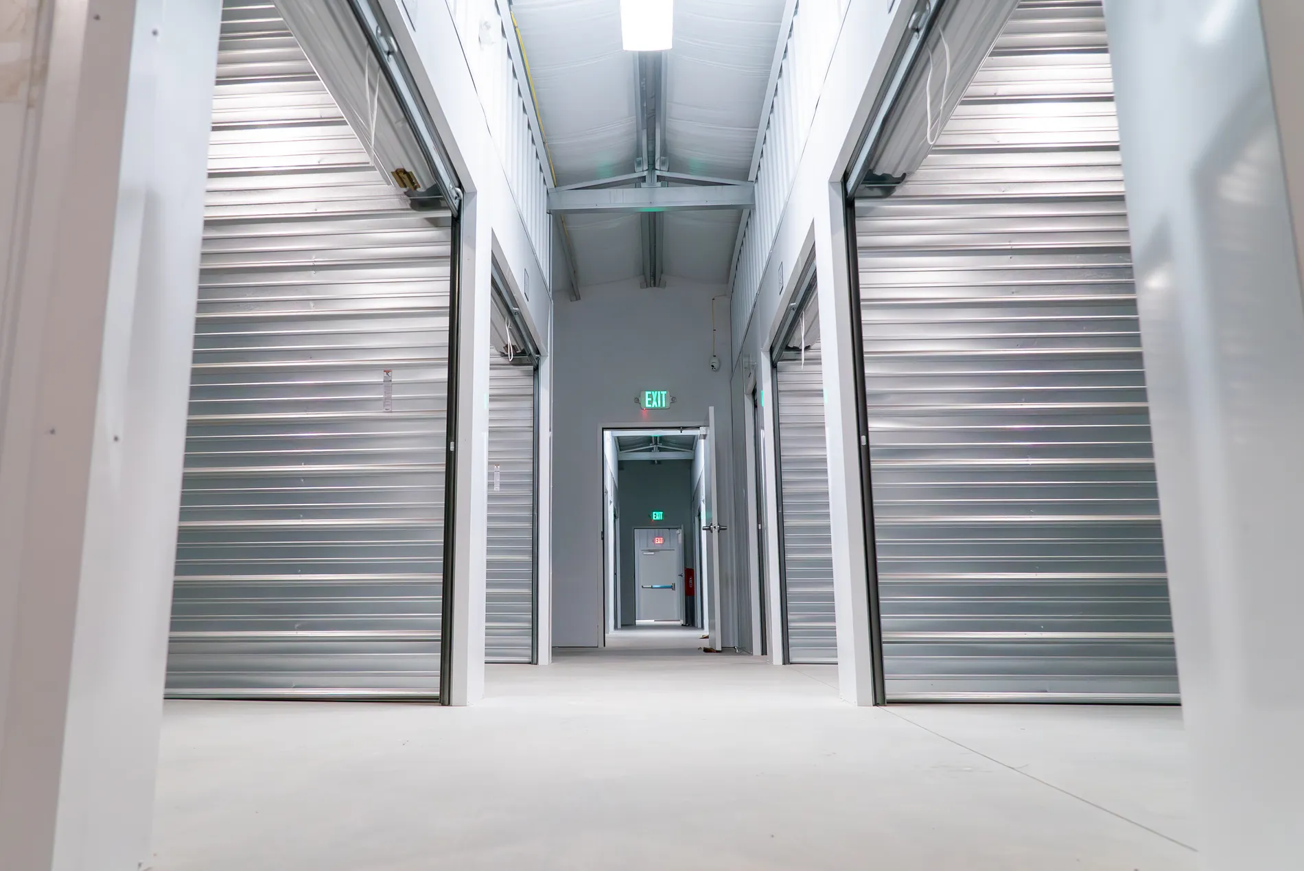 Clean indoor self storage hallway with rows of secure roll up doors